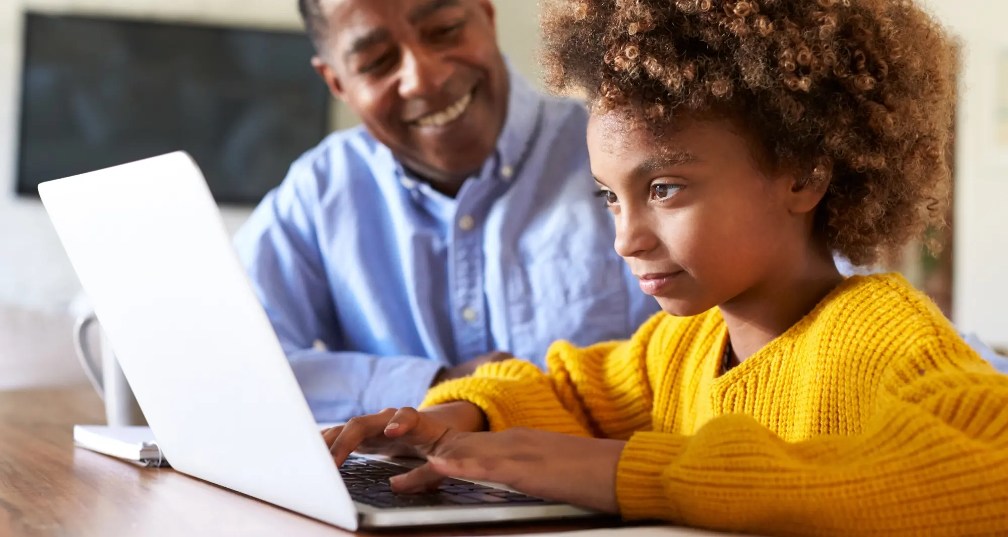 un parent qui supervise son enfant utilisant un ordinateur 