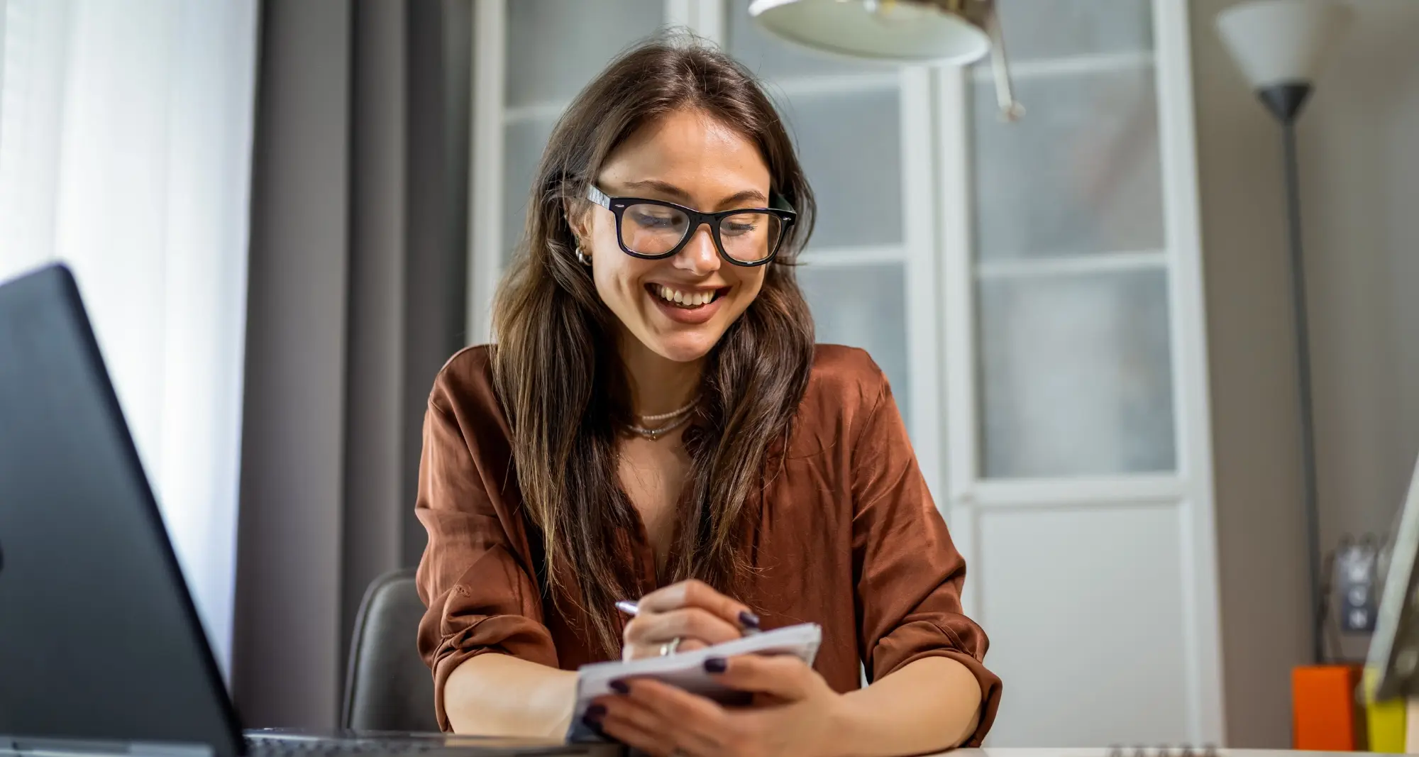 une femme souriante en train de travailler sur sa tablette